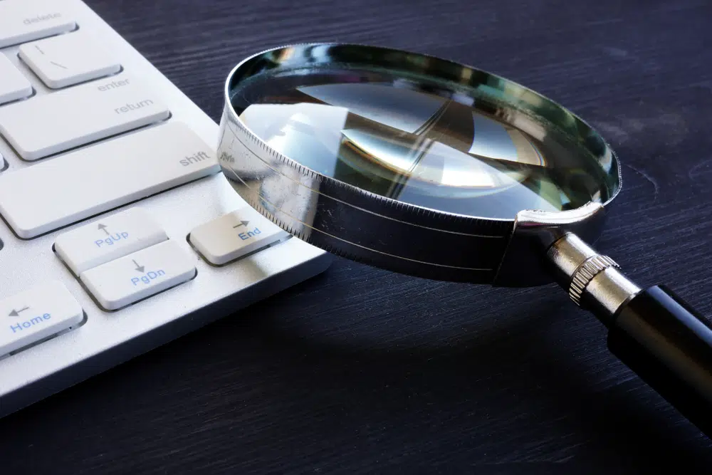 Alt text : Loupe sur clavier d'ordinateur illustrant l'audit de performance et l'analyse objective des données business