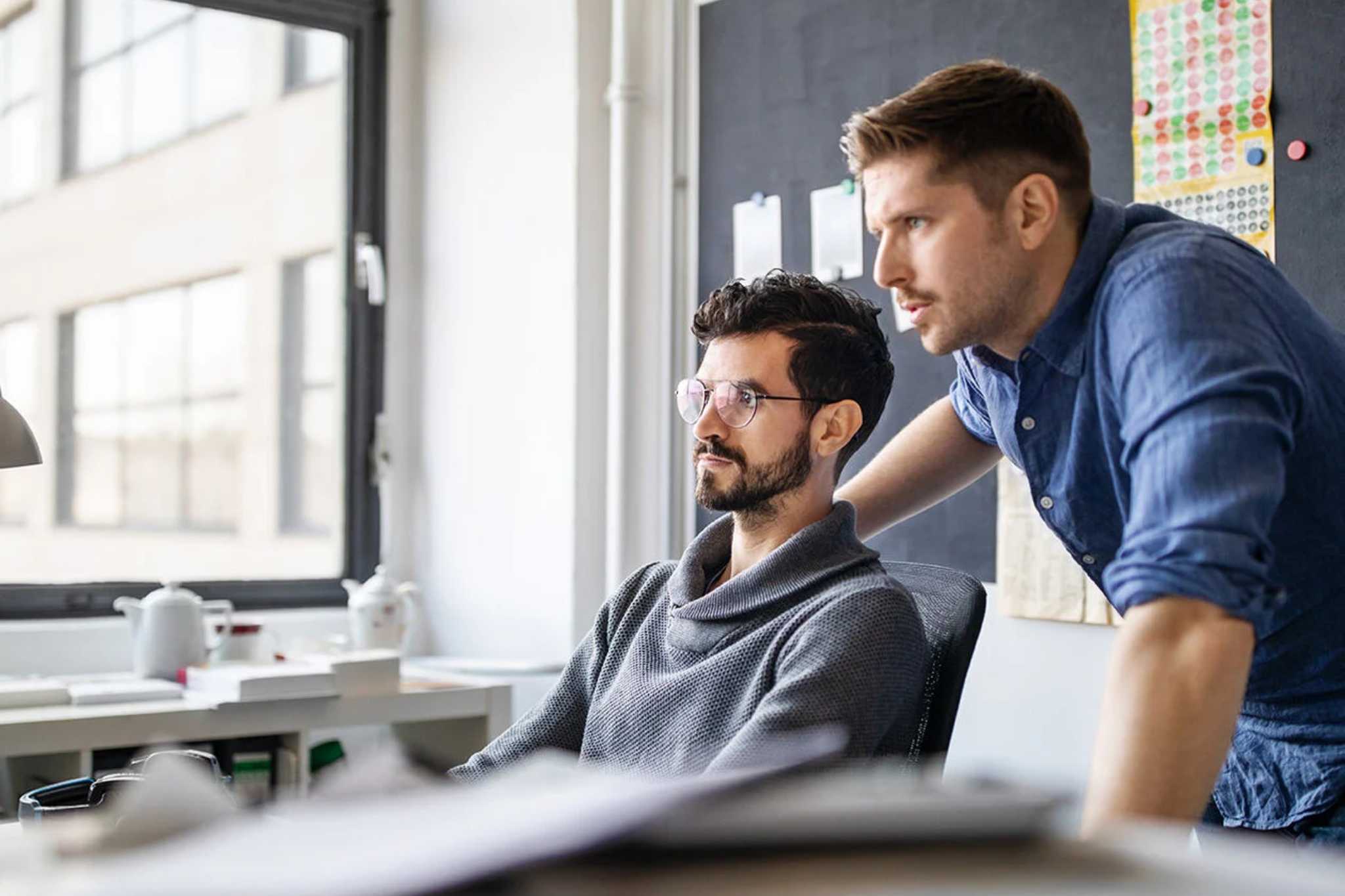 deux collaborateurs devant un écran, travaillant sur un projet de reprise