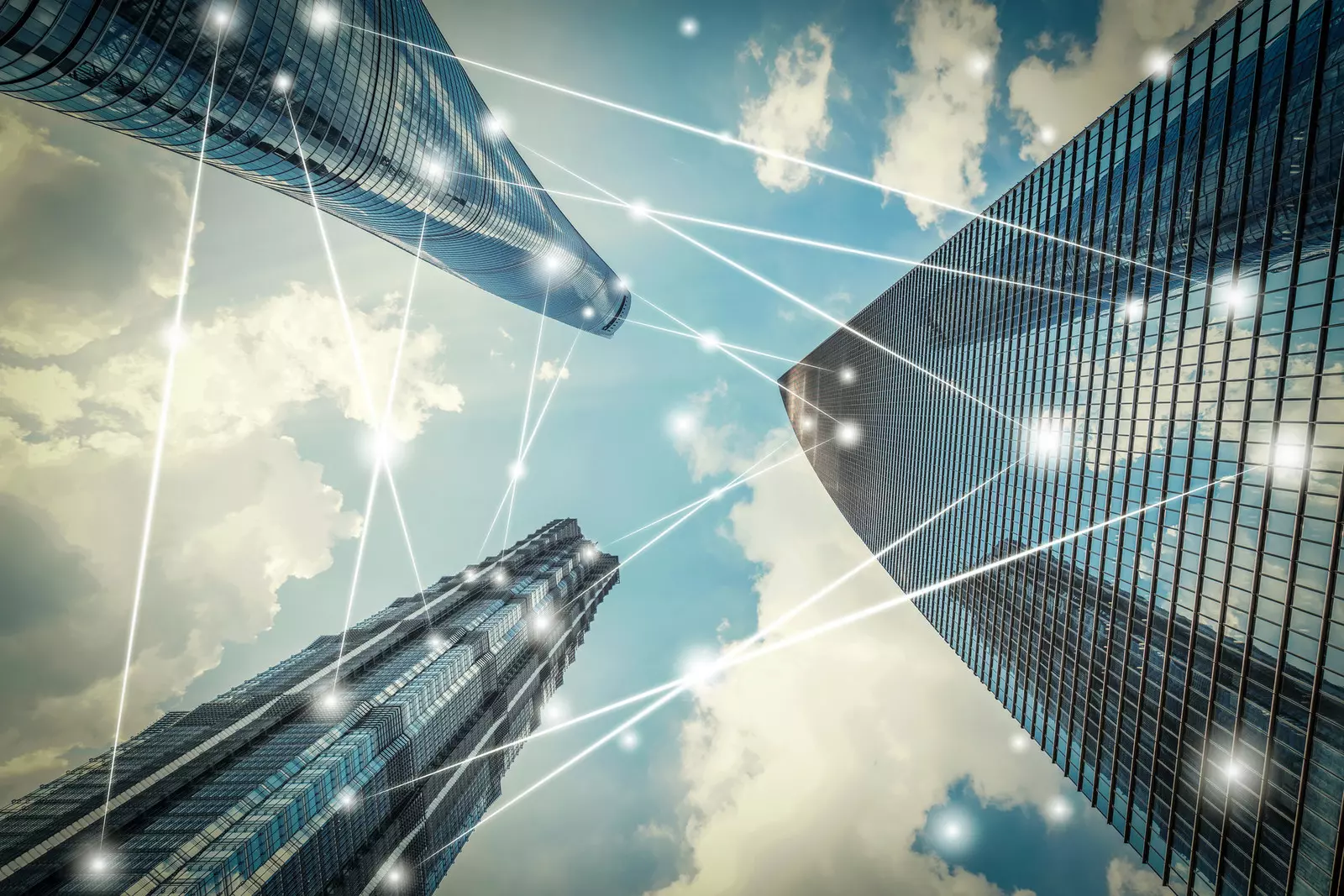 Gratte-ciels urbains interconnectés par des flux de données illustrant le pilotage de la performance immobilière